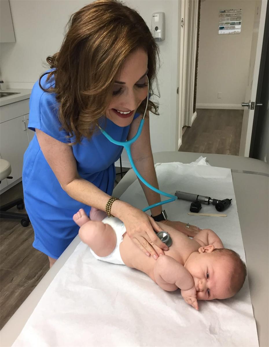 Dr. Tanya Altmann examining an infant with a stethoscope